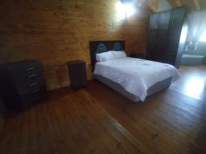 a bedroom with a white bed and a wooden floor at 41onLeo in Eersbewoond
