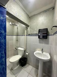 a bathroom with a toilet and a sink at Pousada Amizade in Foz do Iguaçu