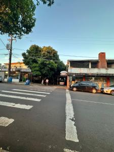 an empty street with cars parked in front of buildings at Pousada Amizade in Foz do Iguaçu