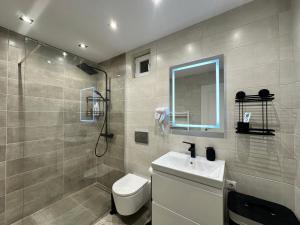 a bathroom with a toilet and a sink and a mirror at Central House - Modern Apartment in Zărneşti