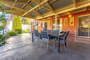 a patio with a black table and chairs at Comfort & Quiet 3BR, CBD 5mins in Kennington