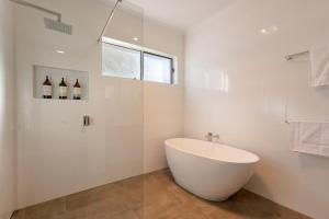 a white bathroom with a tub and a shower at Comfort & Quiet 3BR, CBD 5mins in Kennington +15 photos