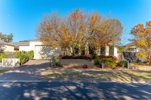 a house with a tree in front of a driveway at Comfort & Quiet 3BR, CBD 5mins in Kennington