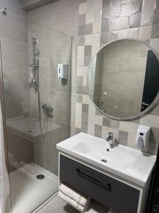 a bathroom with a sink and a shower with a mirror at Pansion Afitos in Laktaši