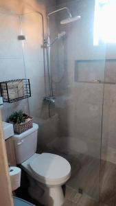 a bathroom with a toilet and a glass shower at El descanso in Higuey