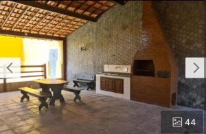 a living room with a table and a stove at Casa em Praia Seca - Ideal para familia- Piscina- Churrasco- Em Condominio in Araruama