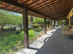 a patio with a hammock under a wooden pergola at Casa em Praia Seca - Ideal para familia- Piscina- Churrasco- Em Condominio in Araruama