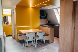 a small kitchen with a wooden table and chairs at Sport- und Ferienpark Worriken in Butgenbach