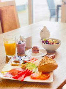 a plate of breakfast foods and a glass of orange juice at Hotel Alter Markt in Berlin