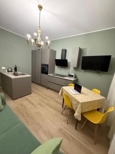 a kitchen and dining room with a table and yellow chairs at Brugnoli 13 Guest House in Bologna