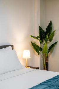 a bedroom with a bed and a plant next to a lamp at Houseloft CityView Hagia Sophia in Thessaloniki