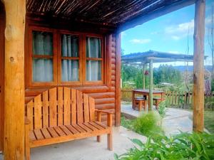 a wooden bench sitting outside of a cabin at Cabañas Rowal Malbec Potrerillos in Potrerillos