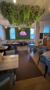 a restaurant with tables and chairs and a tv at The courtyard bar, kitchen, rooms in Falkirk