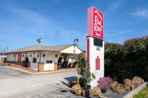 a red rock motel sign in front of a building at Red Roof Inn Arlington - Entertainment District in Arlington