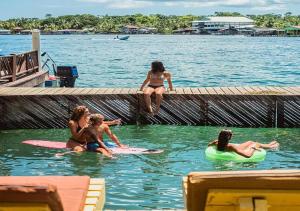 a group of women sitting on surfboards in the water at Klika Bocas del Toro in Bocas Town