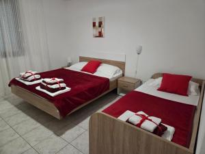 a bedroom with two beds with red and white towels at Villa Bianca in Baška