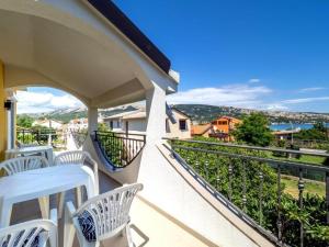 a balcony with white chairs and a view of the water at Villa Bianca in Baška