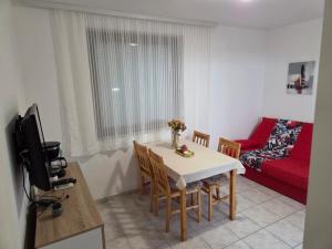 a living room with a table and a red couch at Villa Bianca in Baška