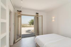 a bedroom with a bed and a large window at Villa Anelya in Parikia
