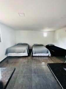 a room with two beds in a room with at Pousada Pazzini in Guarujá