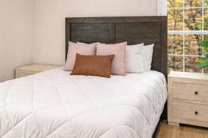 a bedroom with a large white bed with pink pillows at Bird House Pet-Friendly Studio, near Dollywood in Pigeon Forge
