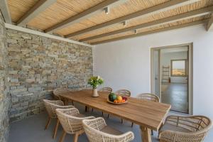 a dining room with a wooden table and chairs at Villa Anelya in Parikia
