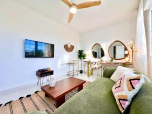 a living room with a green couch and a table at Villa in Playa den Bossa, 5 min SupermarketBBQ in Sant Jordi