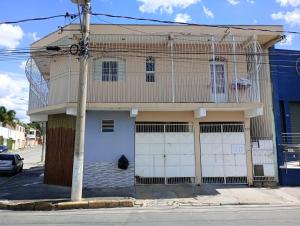 a house with two garage doors on a street at Nossa Senhora Aparecida Apartment in Cachoeira Paulista