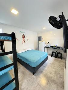 a bedroom with a bunk bed and a kitchen at Pousada Pazzini in Guarujá
