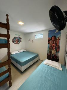 a bedroom with two beds and a bunk bed at Pousada Pazzini in Guarujá