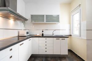 a white kitchen with a sink and a microwave at Houseloft CityView Hagia Sophia in Thessaloniki