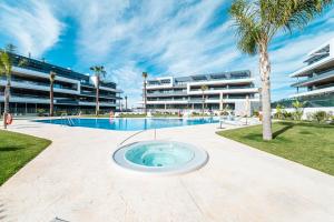 a swimming pool with a frisbee in front of a building at CasaBlanka Premium Apartment with Pool & Wellness in Torrevieja