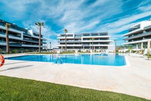 a swimming pool in front of a large building at CasaBlanka Premium Apartment with Pool & Wellness in Torrevieja
