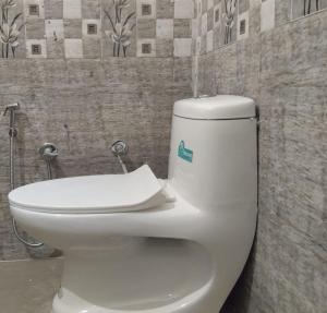a white toilet in a bathroom with a wall at Pushp Vatika Hotel & Resort in Thālera +14 photos