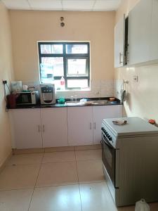 a kitchen with a stove and a window at Hacienda Villa in Juja +7 photos