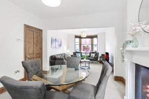 a living room with a glass table and chairs at Home Away I 3BR Comfort Suite I Private Courtyard I Super Fast Wi-Fi I Free Parking in Bedford