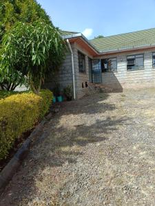 a house with a gravel driveway in front of it at Hacienda Villa in Juja