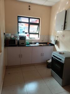 a kitchen with a stove and a window in it at Hacienda Villa in Juja
