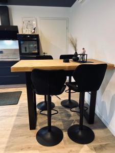 a wooden table with two black chairs and a laptop at Apartment Timeout in Welschbillig