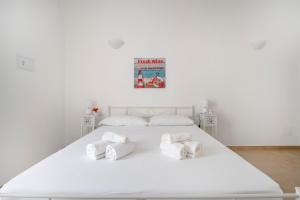 a white bedroom with a large white bed with towels at Ranieri rooms & relax stella in Mola di Bari