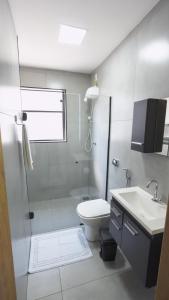 a bathroom with a shower and a toilet and a sink at Jahu Center Lodge in Jaú +33 photos
