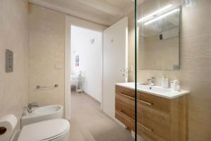a bathroom with a toilet and a sink and a mirror at Ranieri rooms & relax stella in Mola di Bari +28 photos