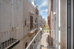 an alley with white buildings and balconies at Ranieri rooms & relax stella in Mola di Bari