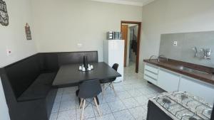 a kitchen with a black table and a refrigerator at Jahu Center Lodge in Jaú