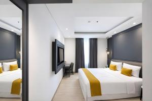 a hotel room with two beds and a tv at Hotel Shalva Jakarta in Jakarta +15 photos