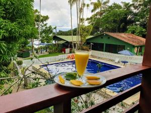 a plate of oranges and a glass of orange juice on a balcony at Bela Vista Lodge in Novo Airão
