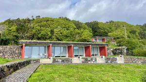 a house on a hill with red columns at Abrigos Baleeiros Turismo Rural in Feiteira