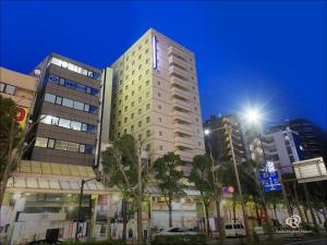 a tall building in a city at night at Daiwa Roynet Hotel Kawasaki in Kawasaki