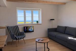 a living room with a couch and a chair at Solhjem Bornholm - Top Rated Sea View Stay in Gudhjem