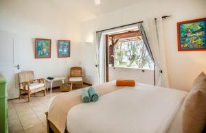 a bedroom with a large white bed and a window at Beach, Blue Sea, Sunset and Private Pool in Rivière Noire